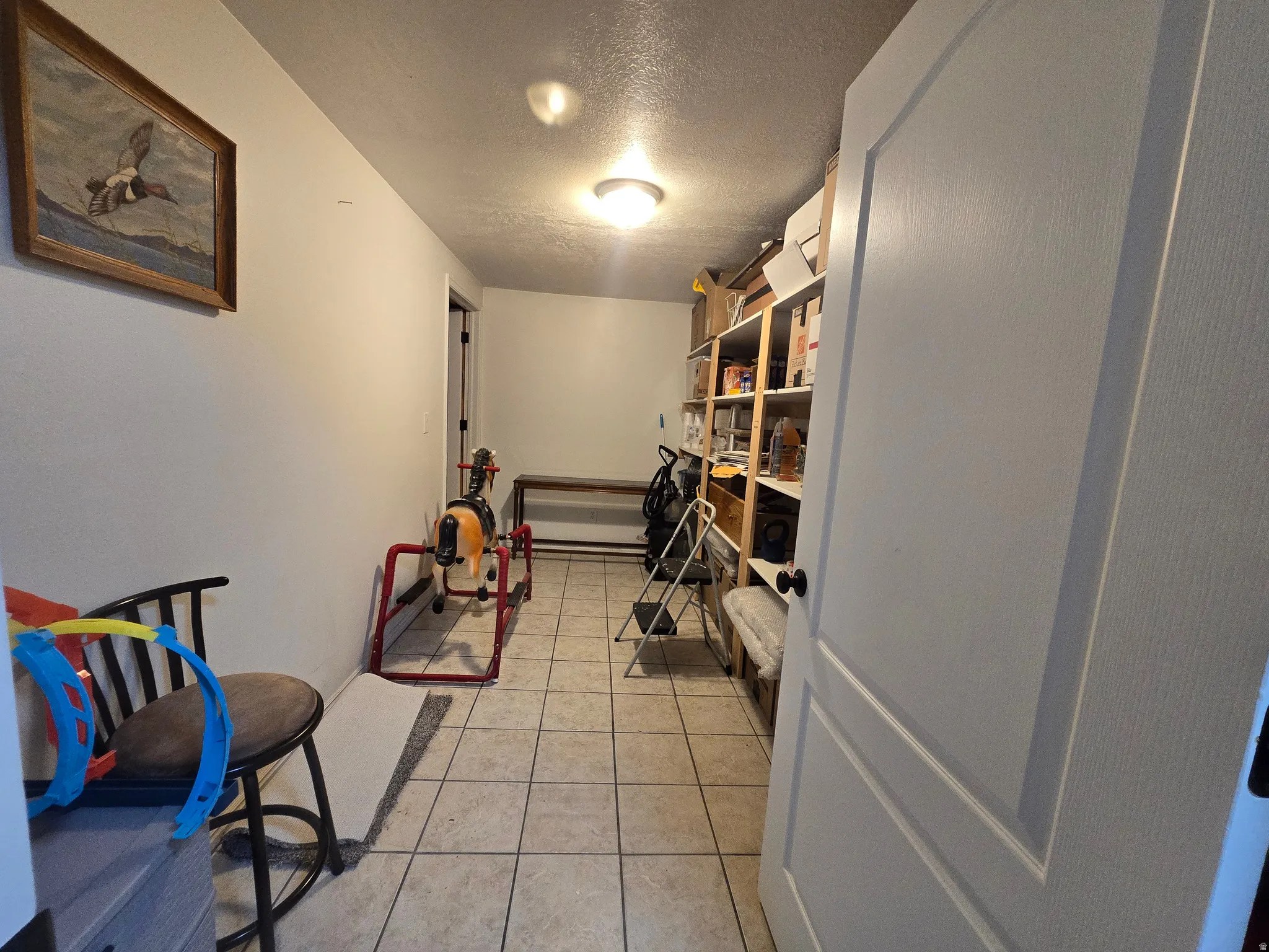 Versatile room featuring tile flooring, built-in shelving, and recessed lighting