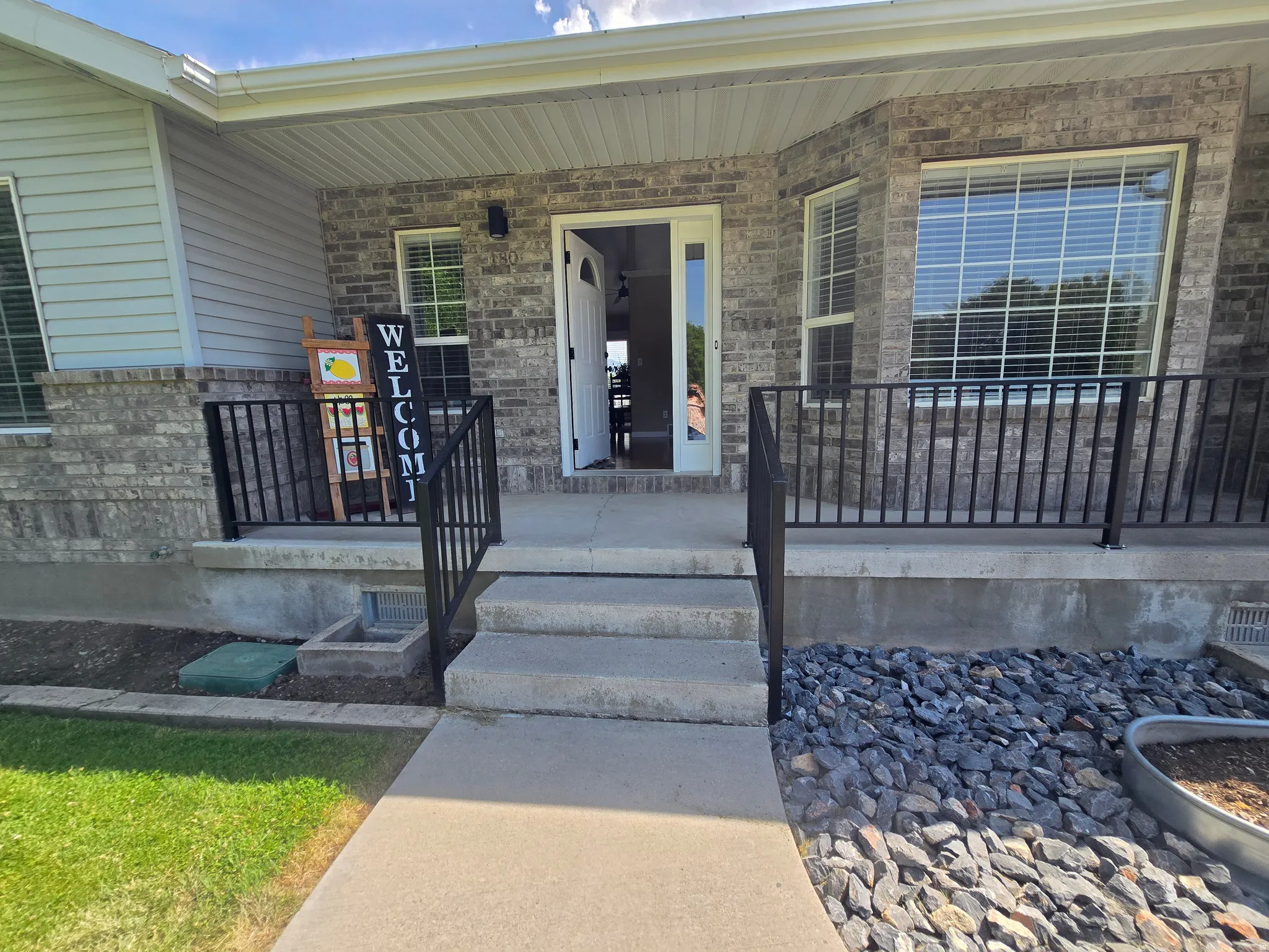 Brick and siding exterior featuring a covered porch entry