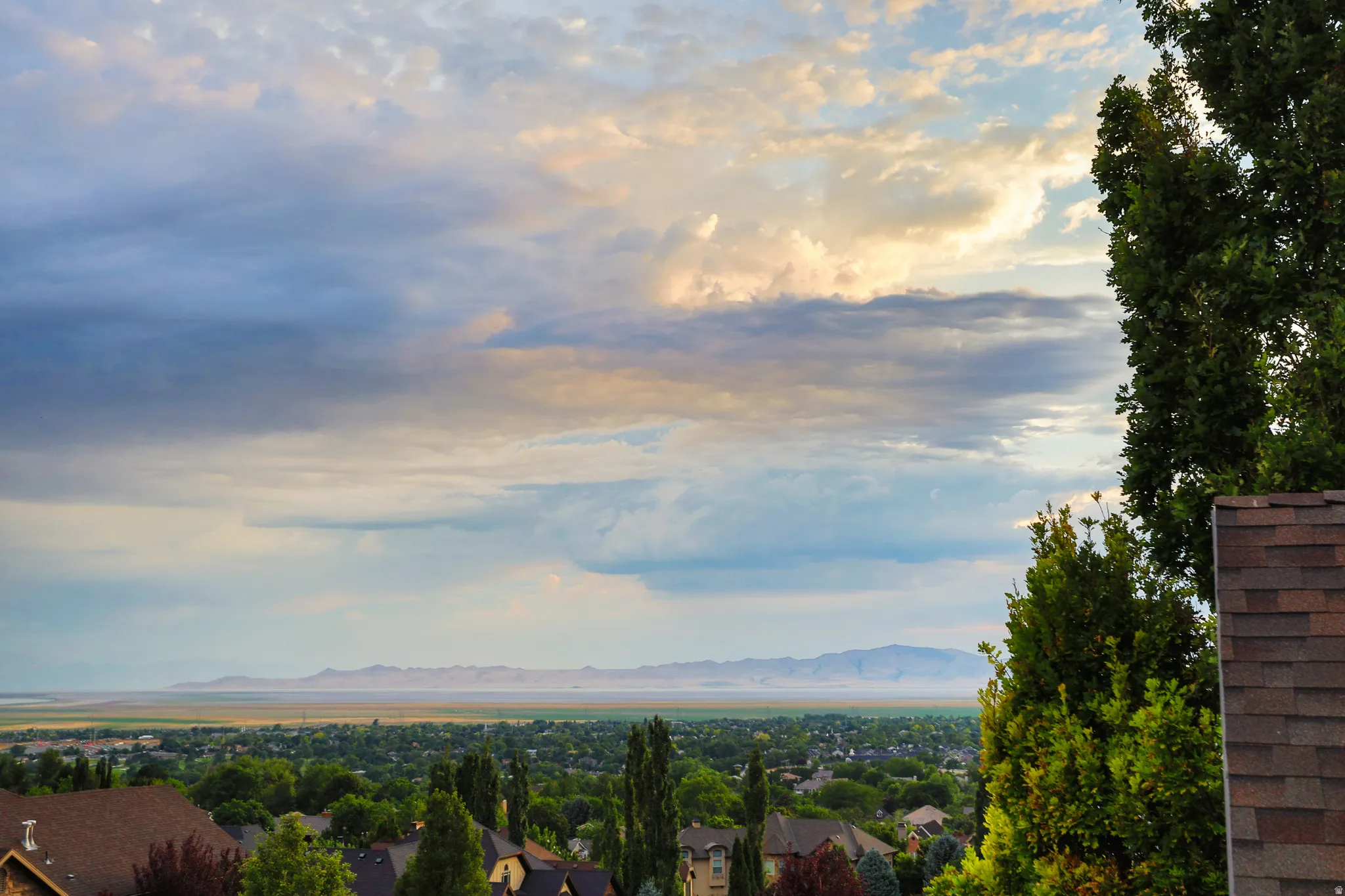 Expansive landscape featuring distant mountains and a body of water under a cloudy sky