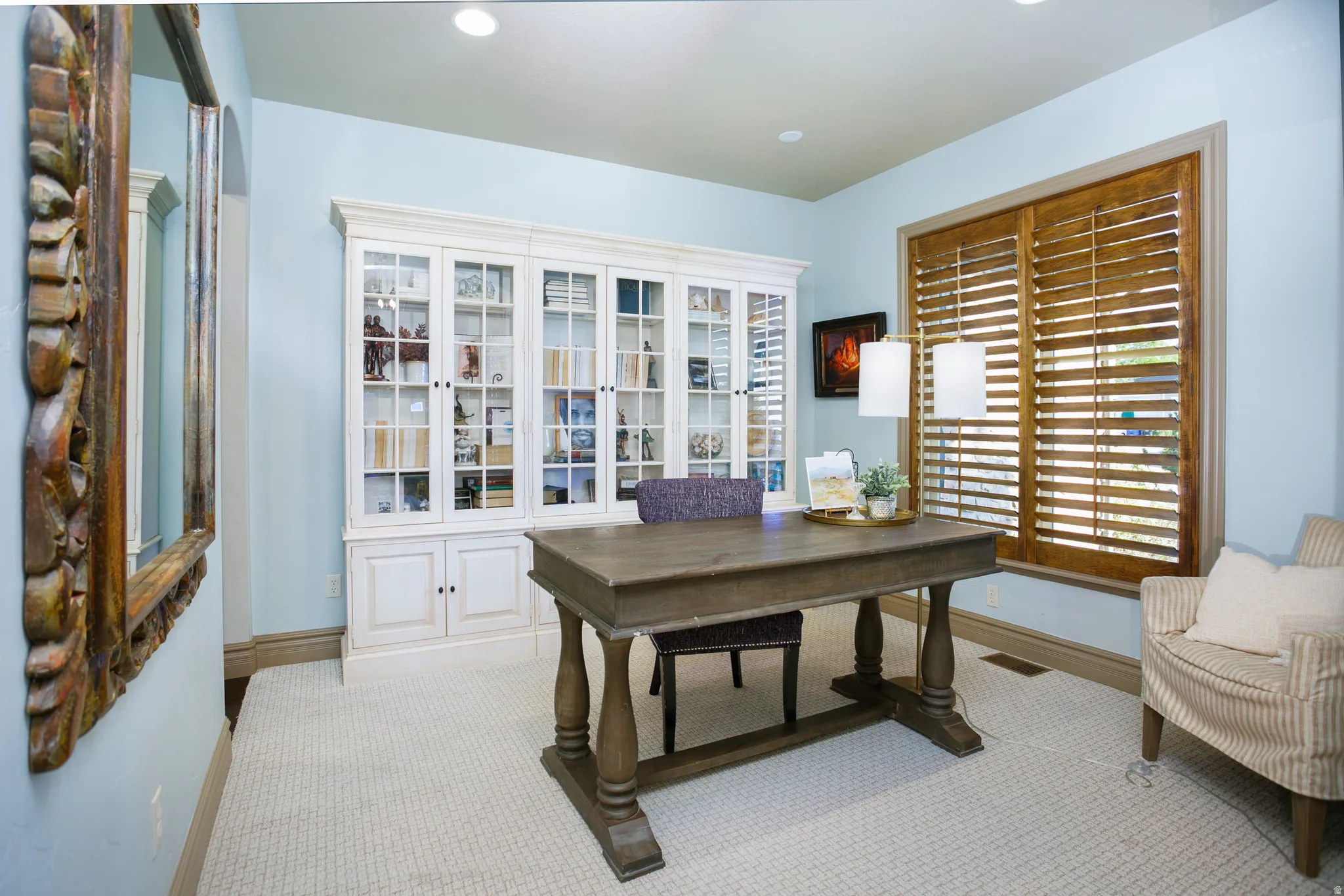 Room with light blue walls, recessed lighting, and patterned carpeting
