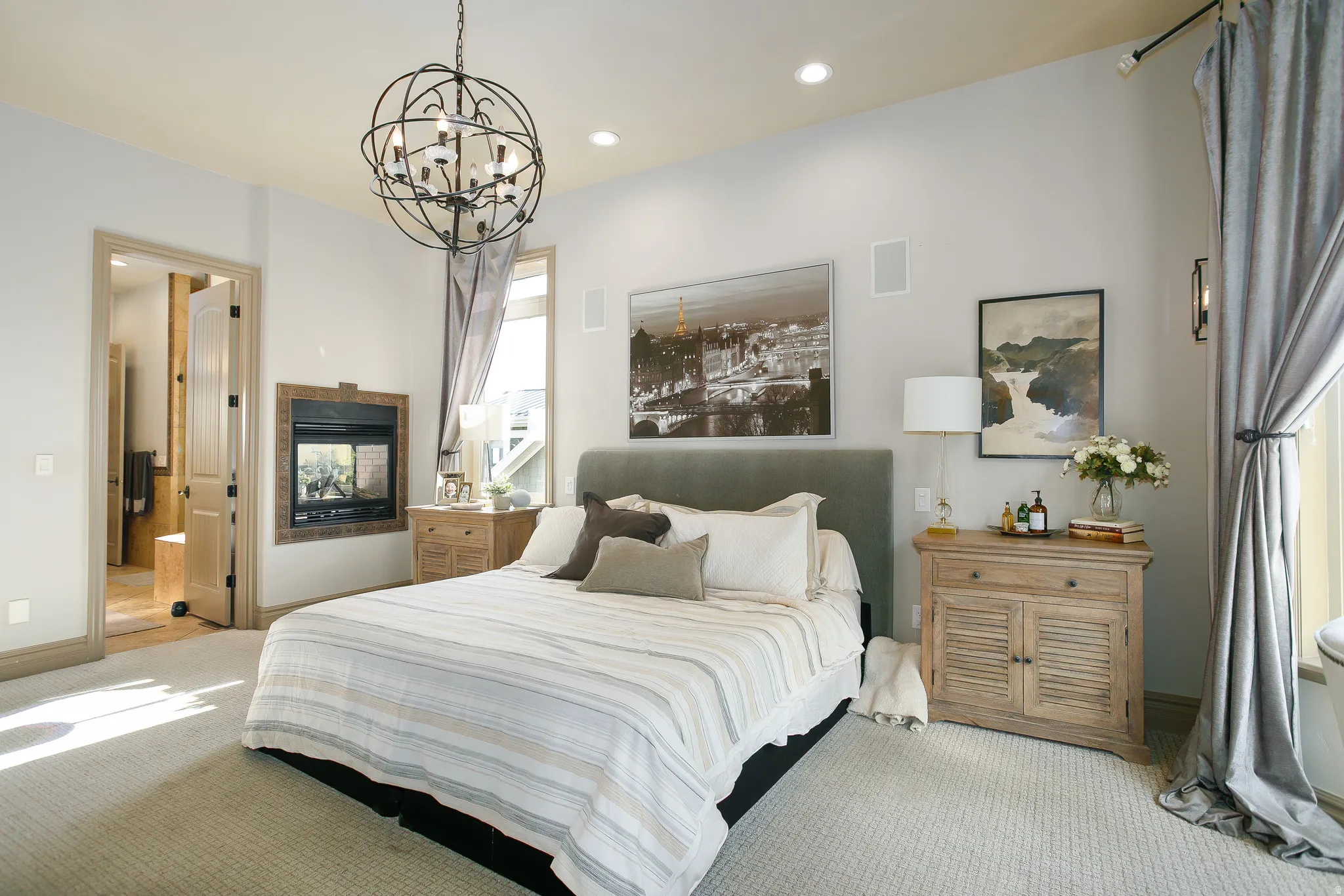 Carpeted room featuring a built-in fireplace, spherical iron chandelier, recessed lighting, and direct access to a bathroom