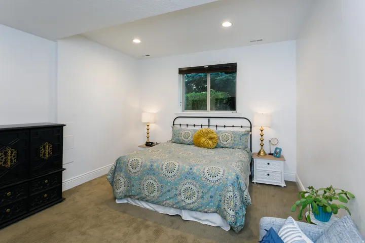 Bedroom featuring recessed lighting, a window with exterior foliage, and carpeted flooring