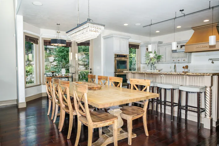 Kitchen and dining area featuring dark wood-finish flooring, a crystal chandelier, recessed lighting, and a kitchen island with beadboard paneling