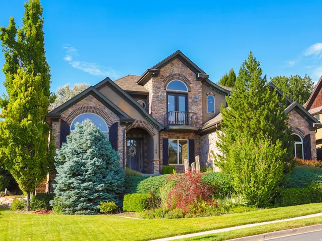 Brick and stucco exterior with multiple arched windows and a front-facing balcony