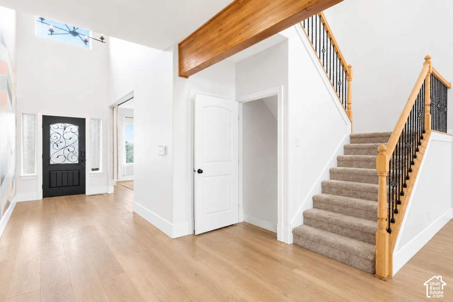 Two-story entry with a dark wood-finish door, sidelight windows, and a transom window