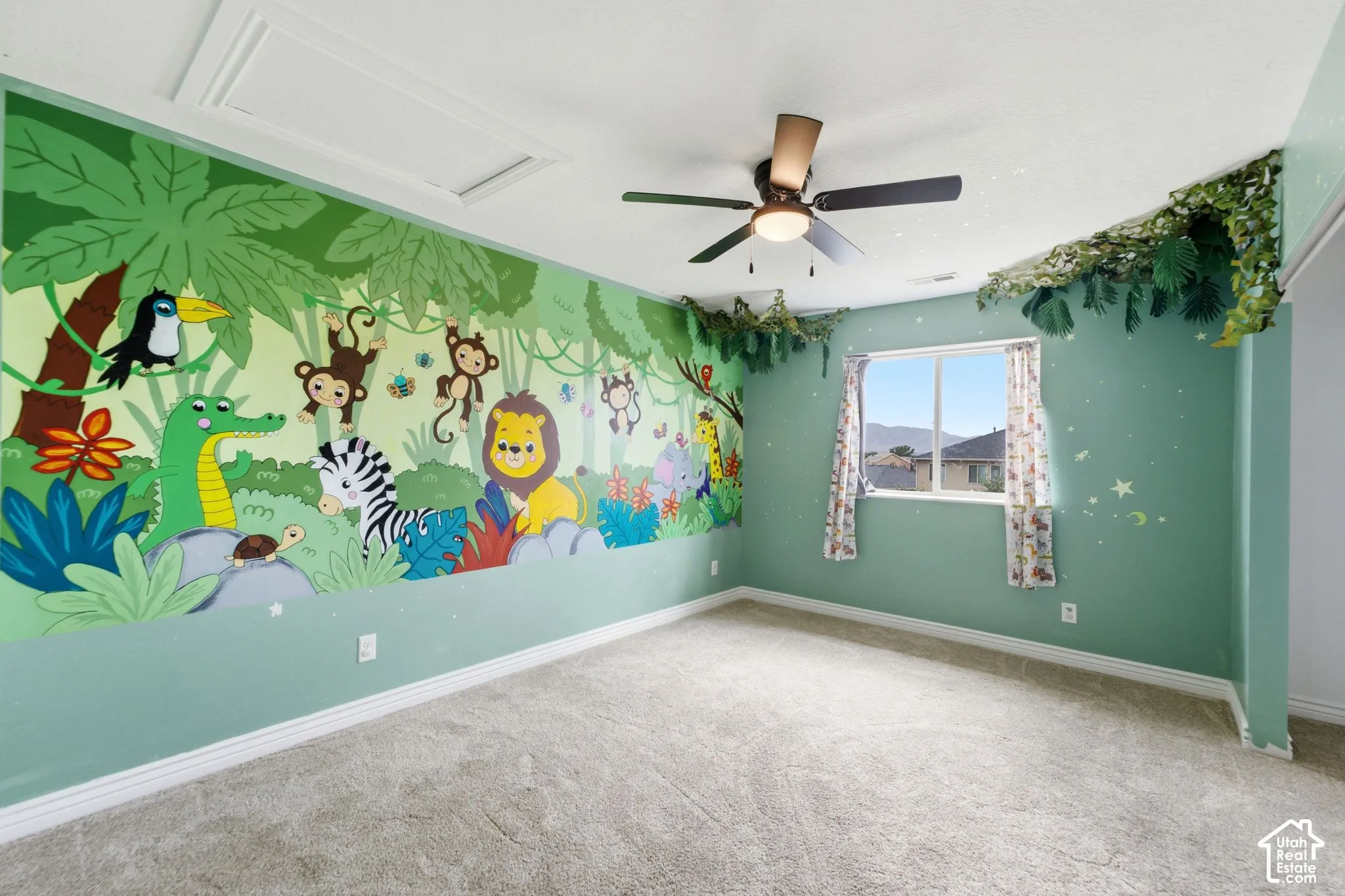 Room featuring a vibrant mural, light green walls, and carpet flooring