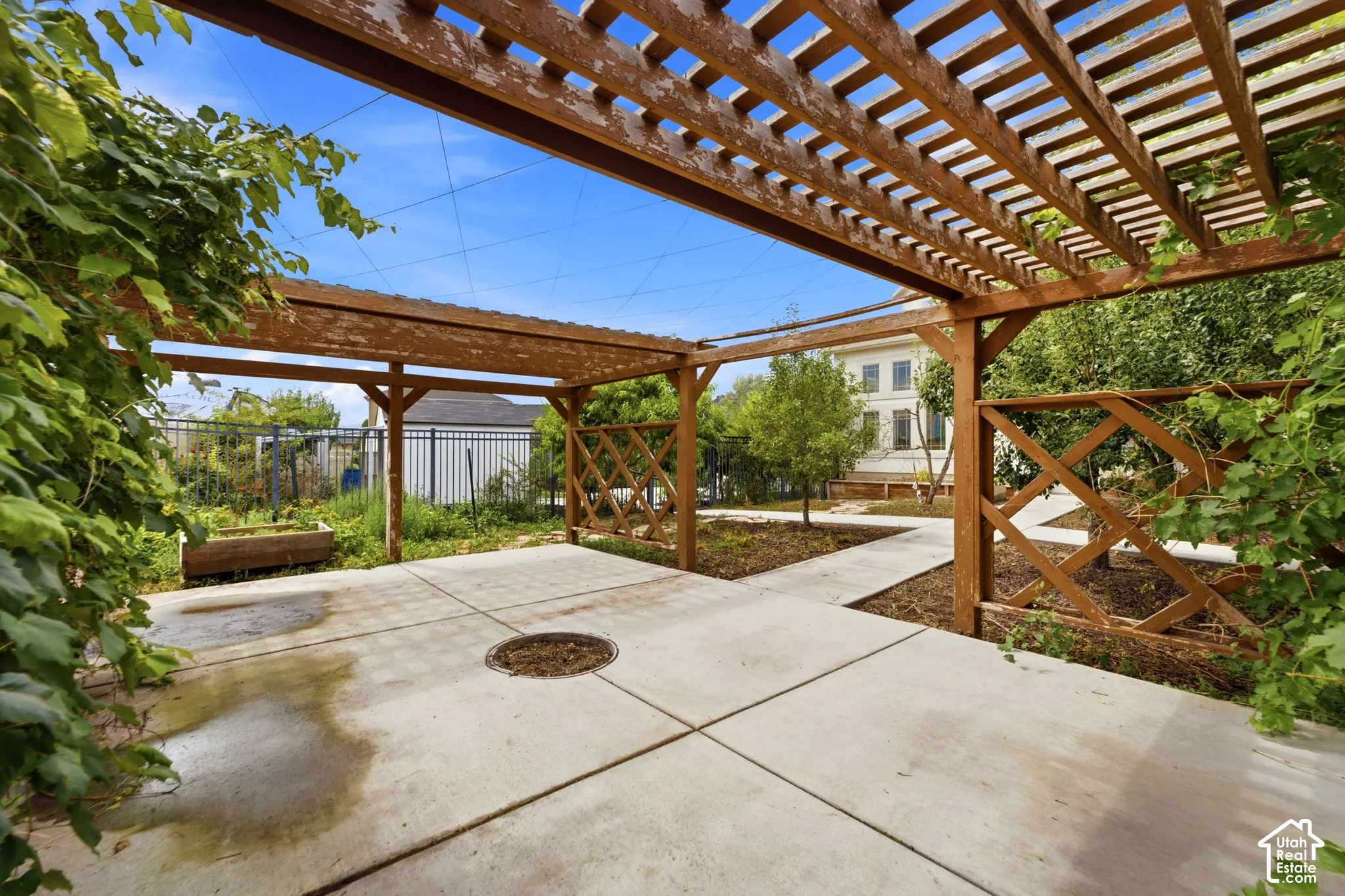 Expansive concrete patio with a large wooden pergola