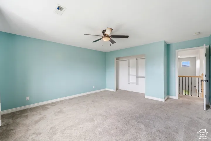 Spacious room featuring light blue walls and gray carpet flooring