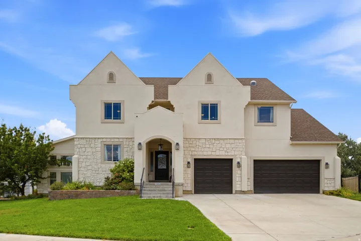 Stucco and stone facade home featuring a prominent arched entry