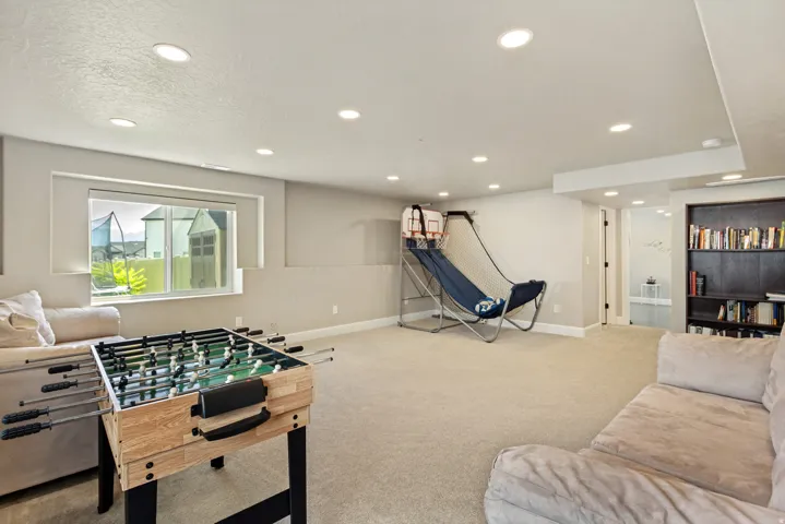 Spacious lower-level room featuring recessed lighting, light-colored carpeting, a window providing natural light