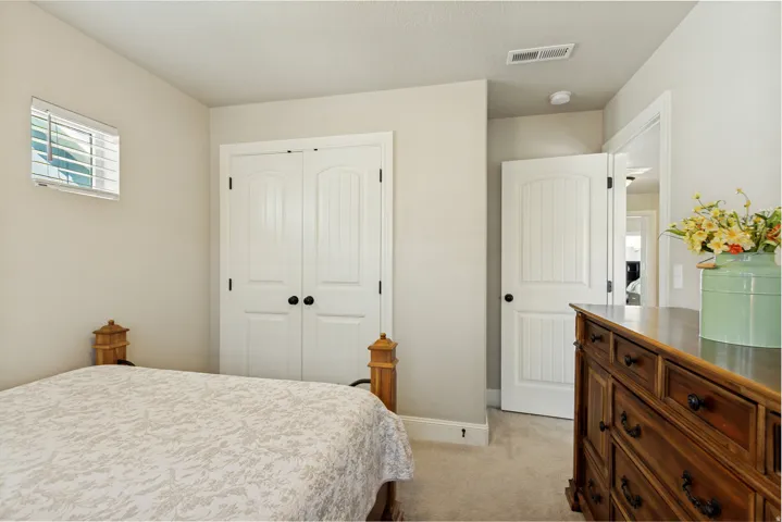 Bedroom featuring neutral wall paint, light-toned carpet, and a window with horizontal blinds