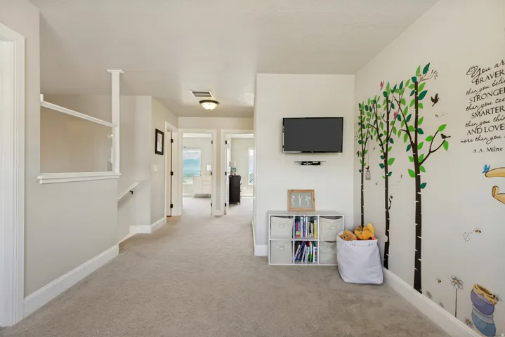 Carpeted hallway featuring multiple doorways, recessed lighting, and white baseboards