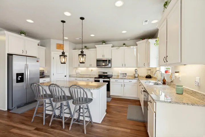 Kitchen featuring white cabinetry, granite countertops, stainless steel appliances, and recessed lighting