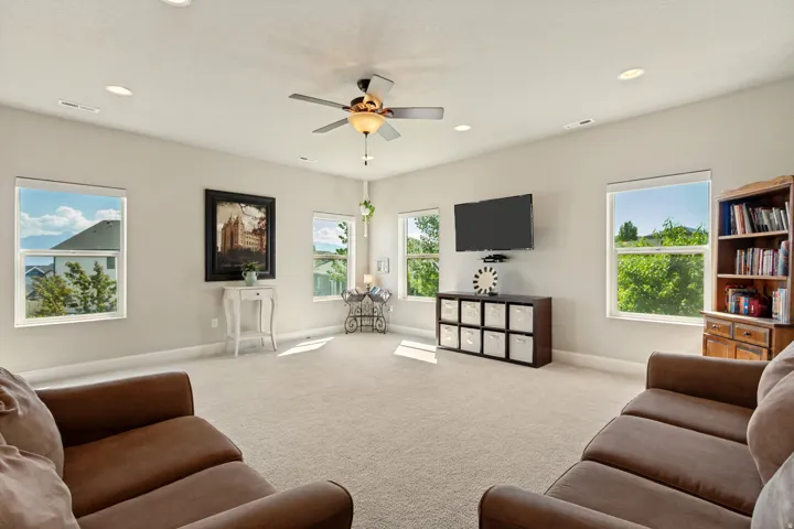 Spacious room with light neutral wall tones, recessed lighting, and a ceiling fan