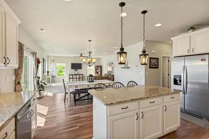 Kitchen island with a light-colored countertop, white cabinetry, and two pendant lights