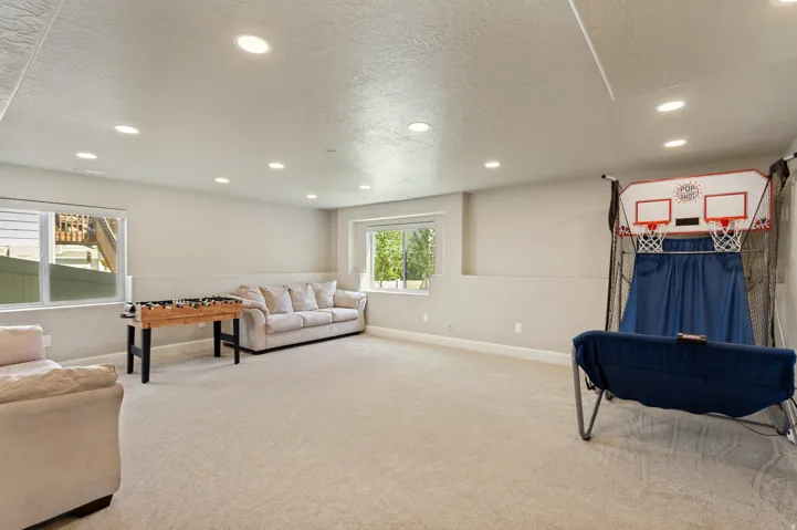 Spacious room featuring neutral carpeting, recessed lighting, two windows with white blinds, and light-colored walls