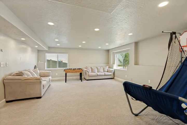 Spacious room featuring neutral carpeting, recessed lighting, and multiple windows providing natural illumination