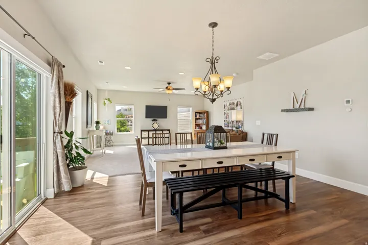 Open-concept dining and living area featuring a decorative chandelier, and recessed lighting