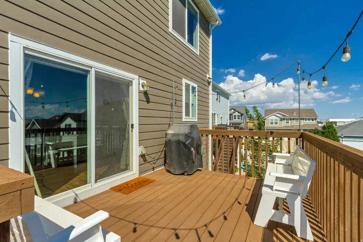 Expansive outdoor deck featuring wood-finish flooring and a wood railing