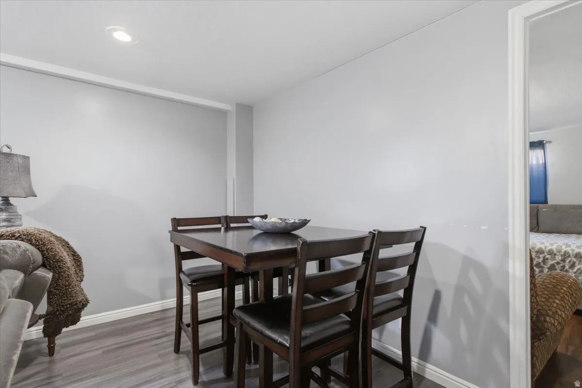 Recessed ceiling lighting illuminates the dining area with wood-finish flooring
