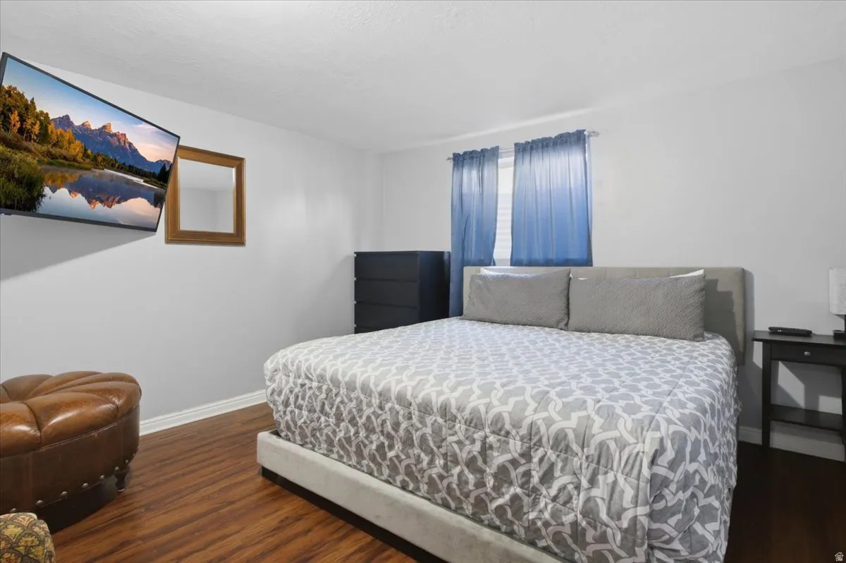 Interior room featuring wood-finish flooring, a wall-mounted television, and light-toned walls