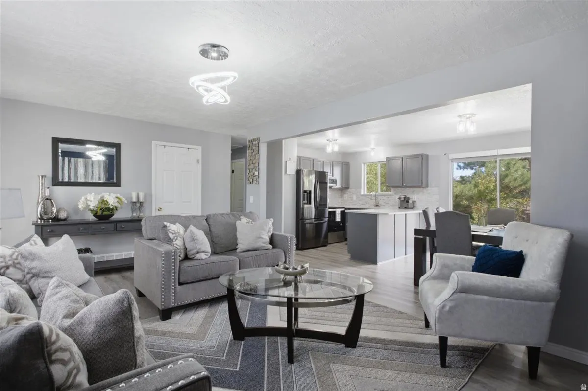 Open-concept living space featuring wood-finish flooring, recessed lighting, and light gray wall tones