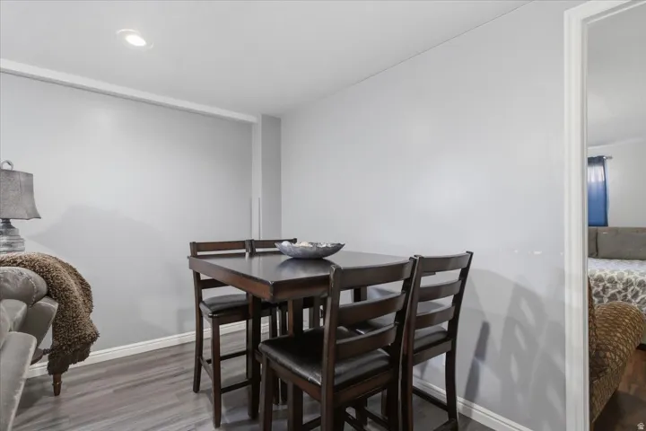 Recessed ceiling lighting illuminates the dining area with wood-finish flooring
