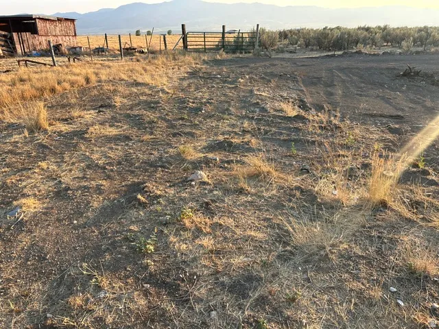 Expansive land parcel featuring natural ground cover and distant mountain scenery
