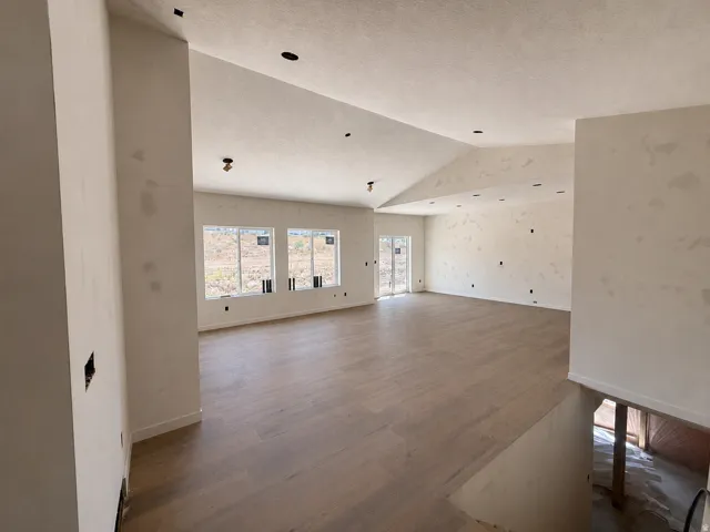Spacious interior featuring wood-finish flooring, vaulted ceilings, and recessed lighting