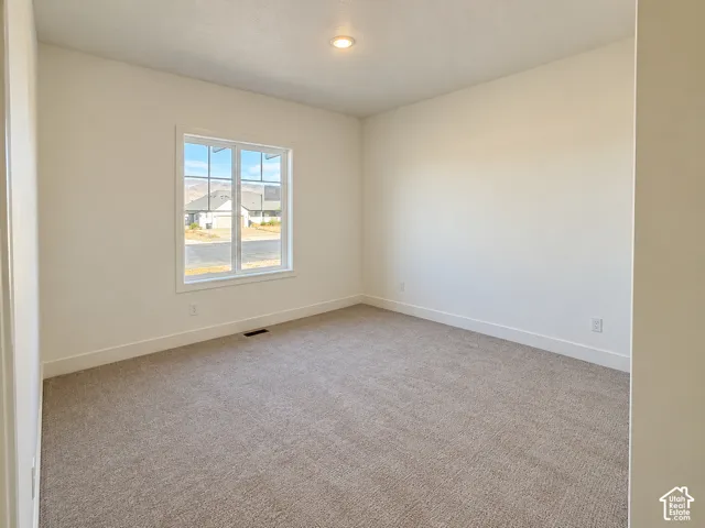 Neutral-toned carpeting, recessed ceiling lighting, and a multi-pane window featuring mountain scenery