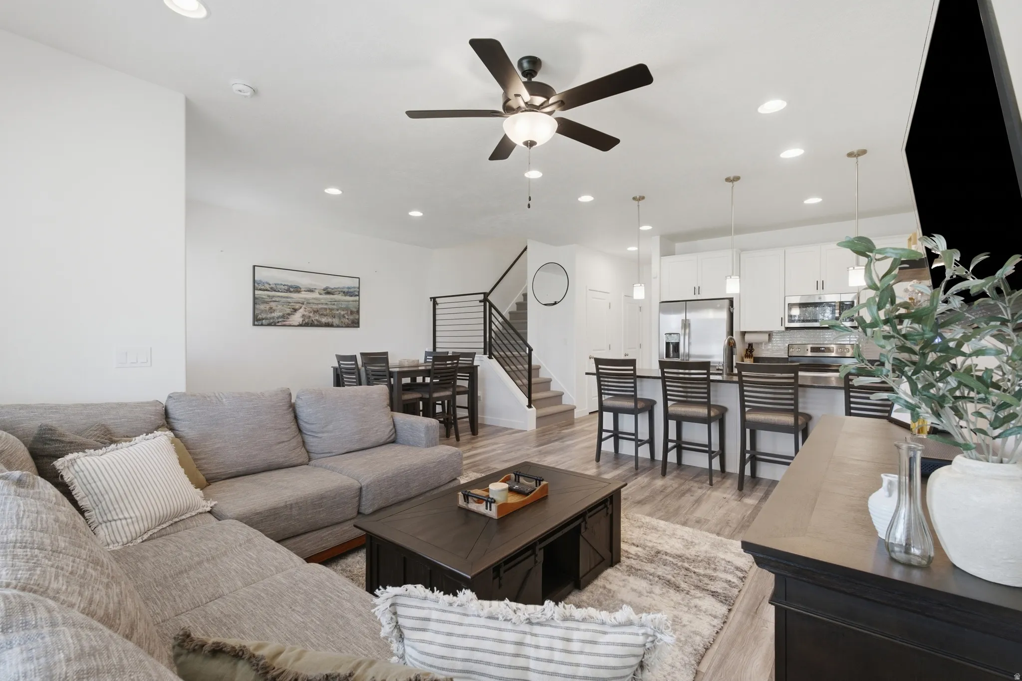 Spacious living area featuring light wood-finish flooring and recessed lighting