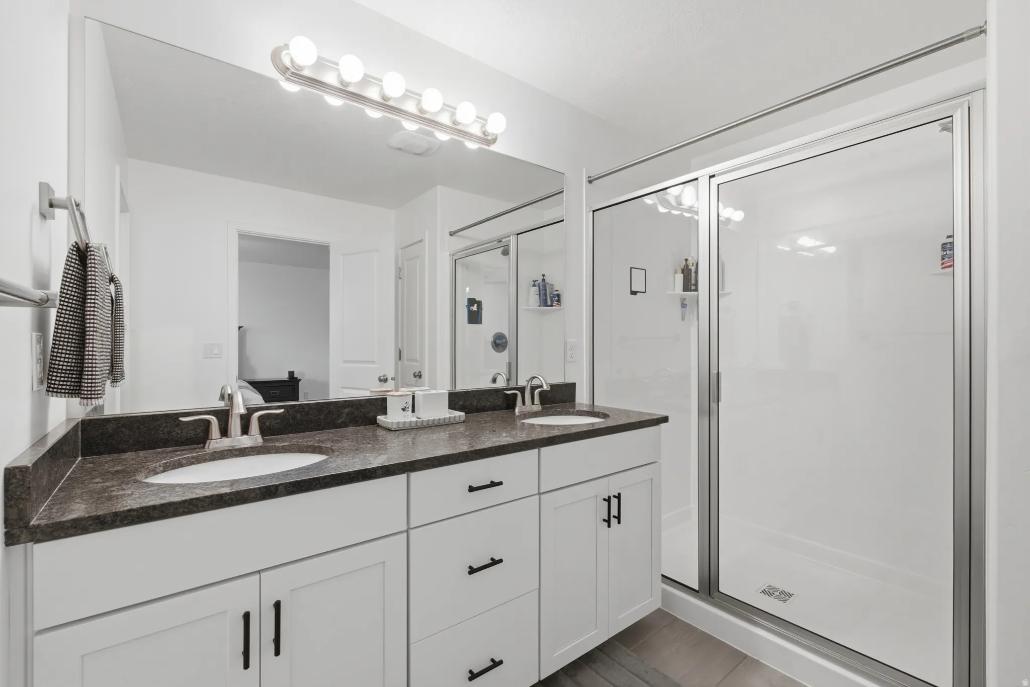 Double vanity with undermount sinks and dark countertops