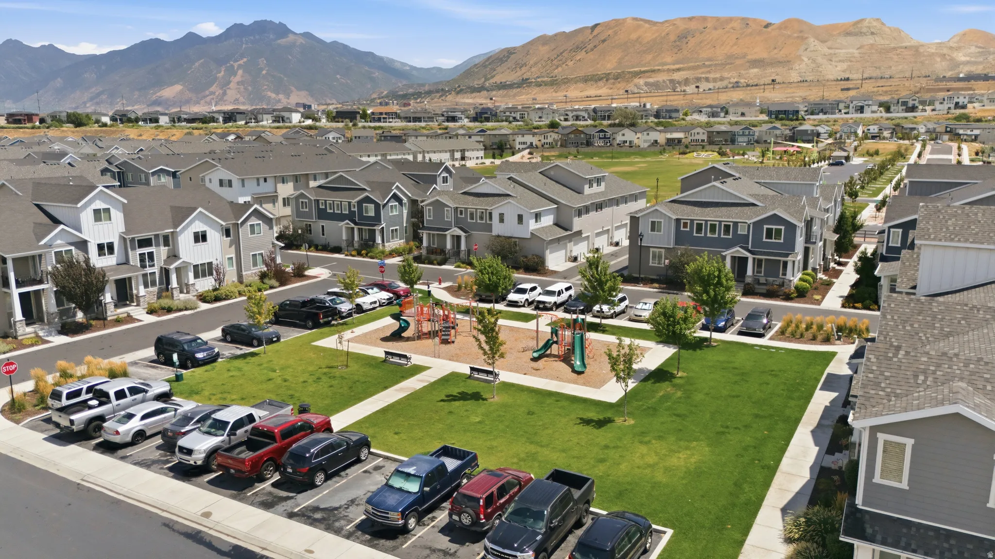 Community green space featuring a playground with slides and swings, surrounded by residences