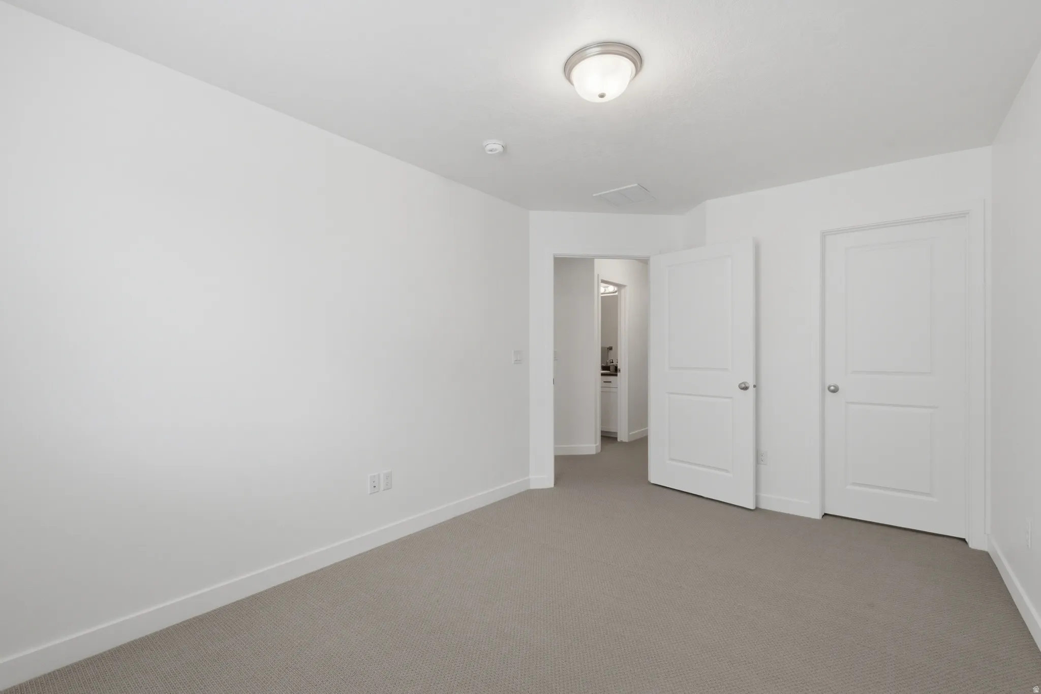 Carpeted room featuring white walls, white trim, and a semi-flush ceiling light fixture