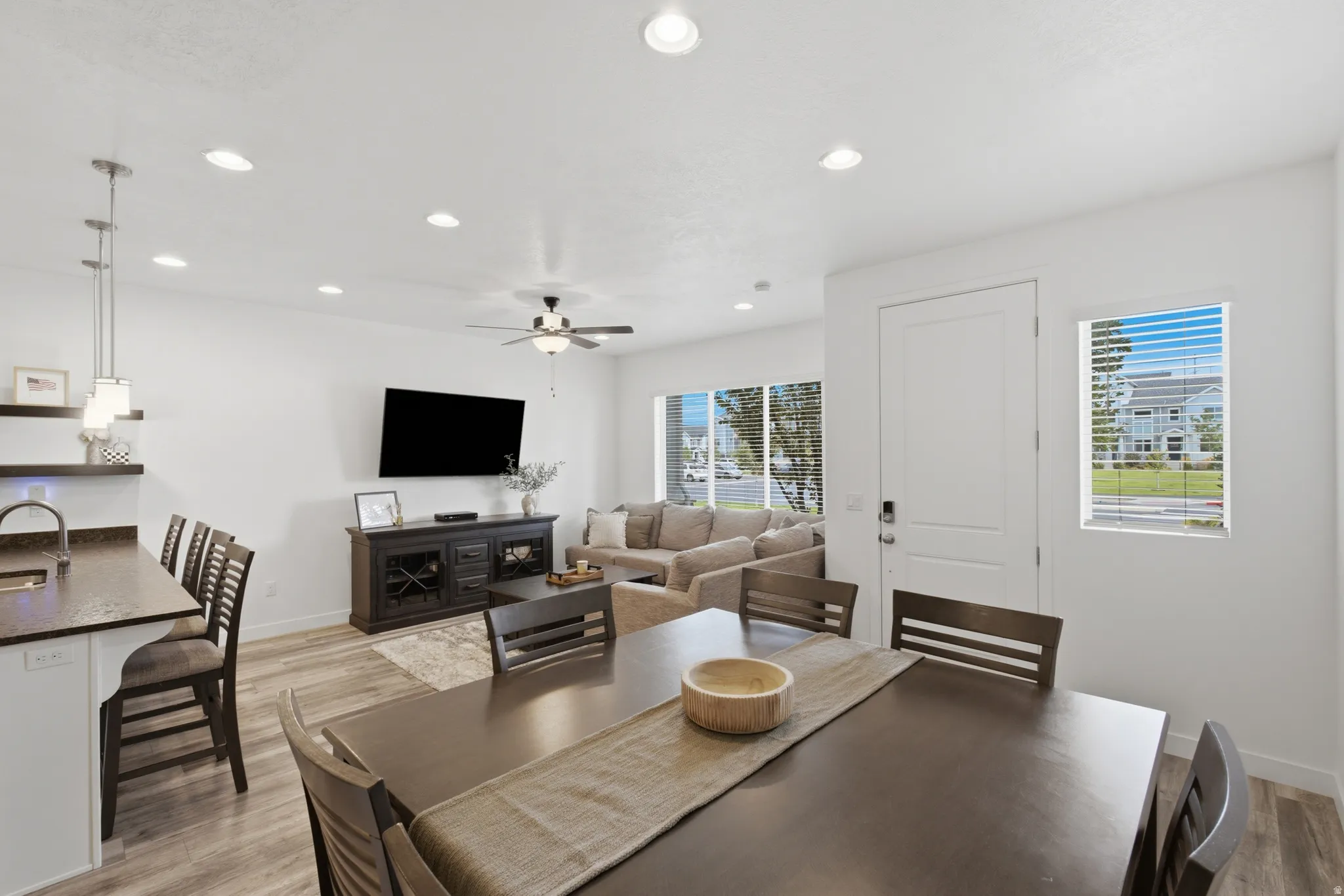 Open-concept living space featuring wood-finish flooring, recessed lighting, and a ceiling fan