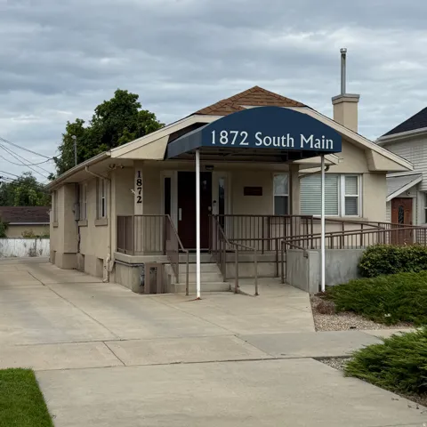 Stucco exterior with a peaked roof and a prominent entry canopy