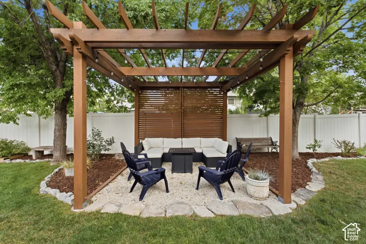 Charming pergola with string lighting and a slatted privacy screen.