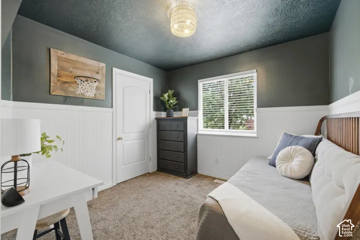 Bedroom featuring beautiful wainscoting, and dark contrasting walls & ceiling.