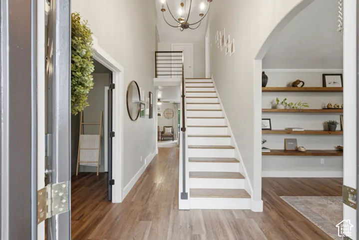 An inviting foyer with wood-finish flooring and modern staircase.