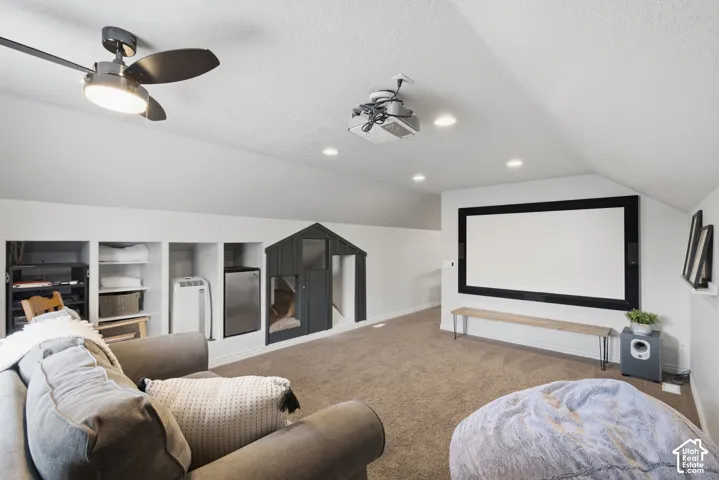 Spacious media room includes a raised sitting area and a large projection screen.