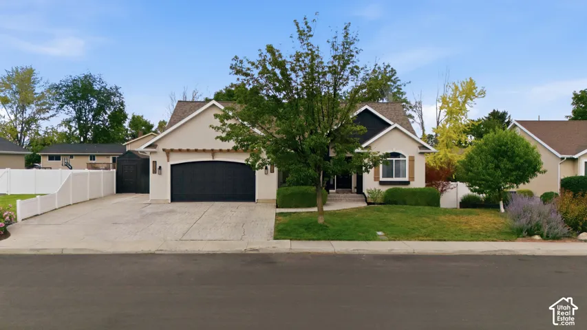 Stucco exterior with a dark-paneled garage door, arched porch entry, and a pitched roof.