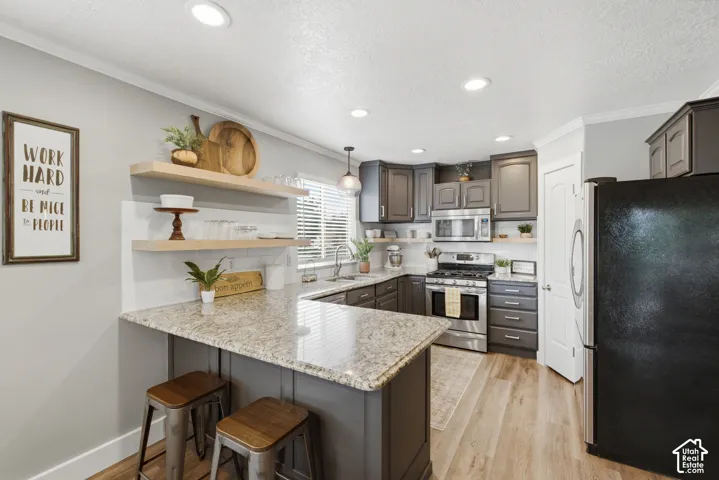 Charming kitchen with floating wood shelves above the peninsula.