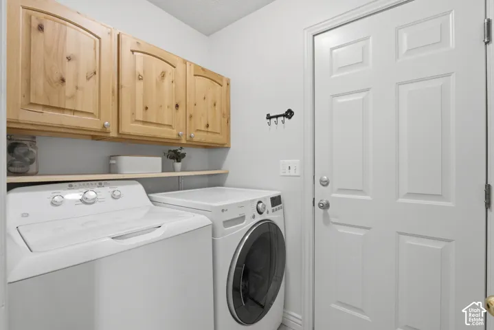 Laundry area featuring wood cabinetry, and shelf.