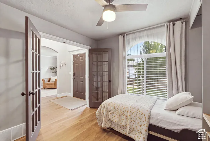 Flex room featuring hardwood flooring, a and a large arched window allowing for plenty of natural light.