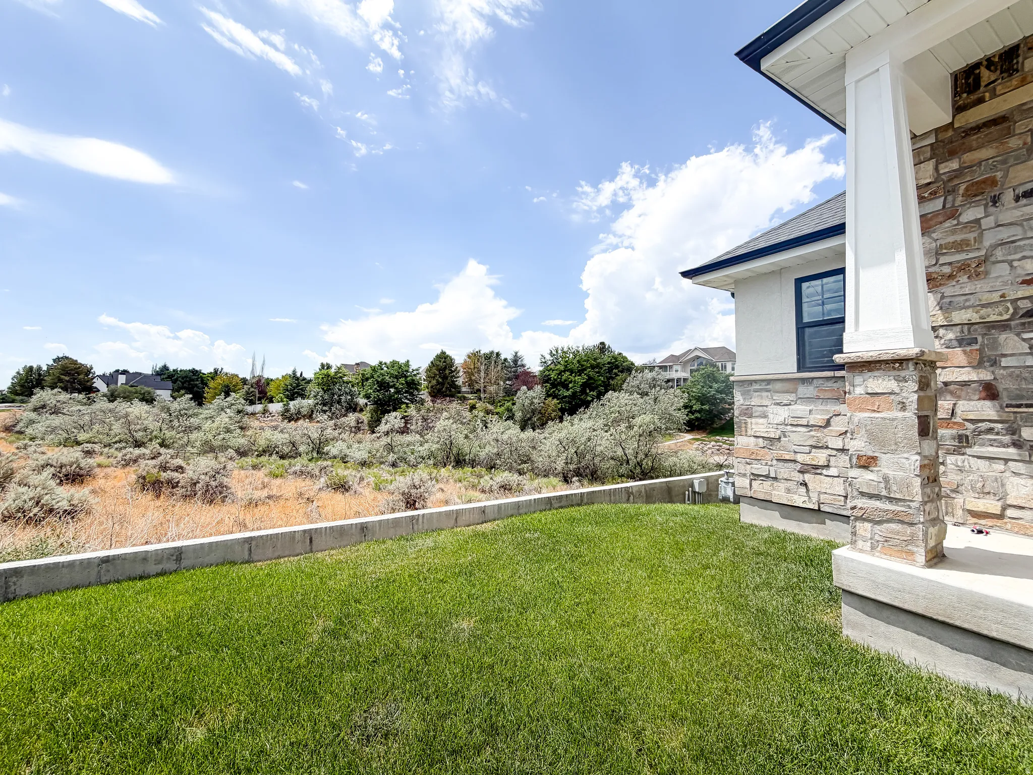 Exterior featuring a stone veneer facade and white columns