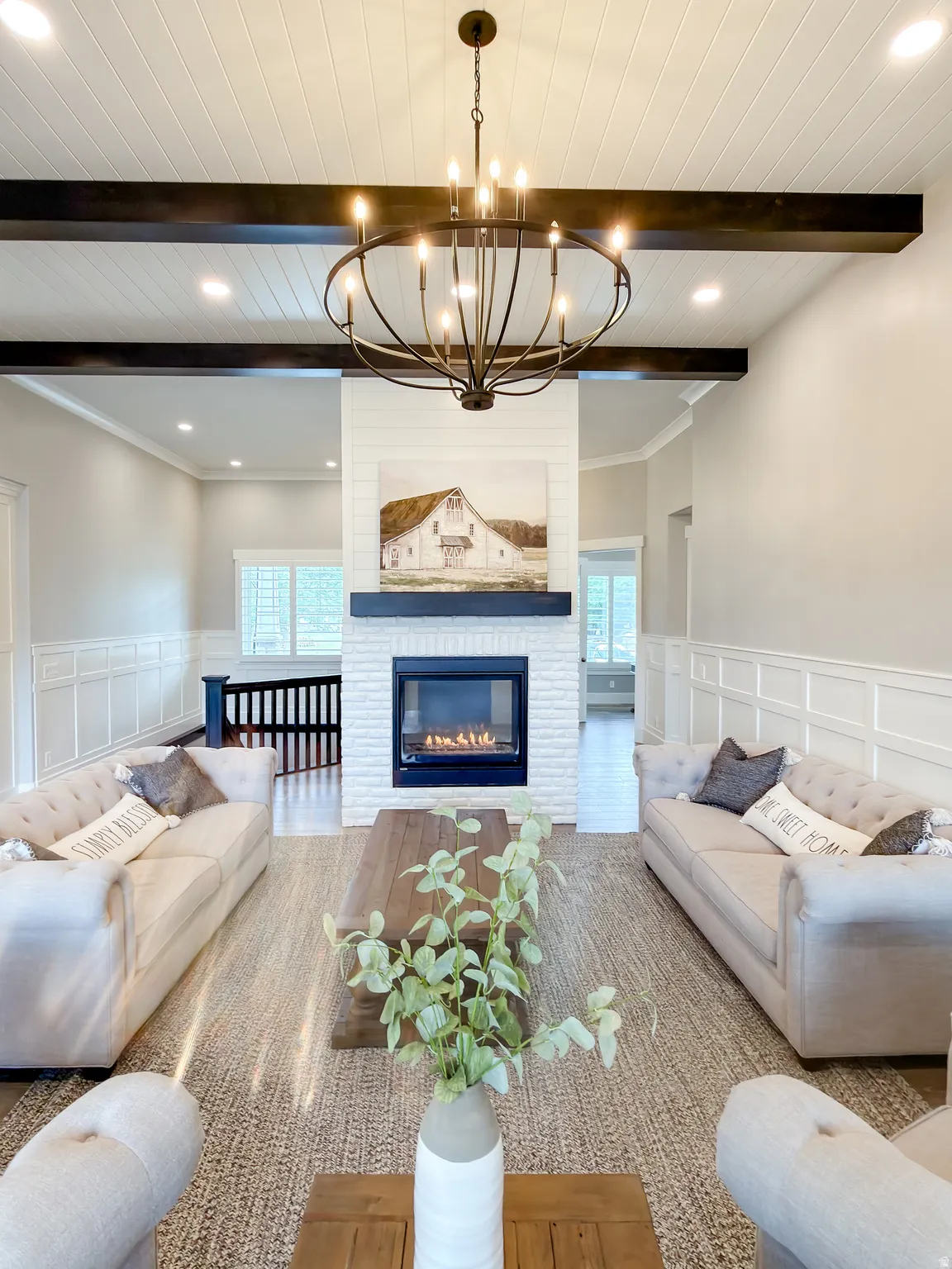 Spacious living area featuring a central fireplace with white brick surround and dark wood mantel