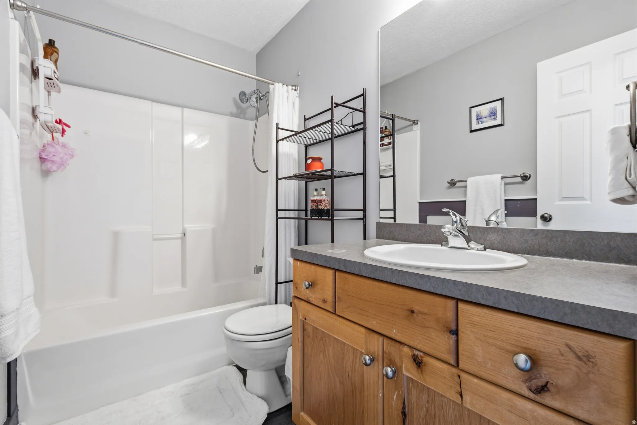 Bathroom featuring a wood-finish vanity with an integrated sink and gray countertop