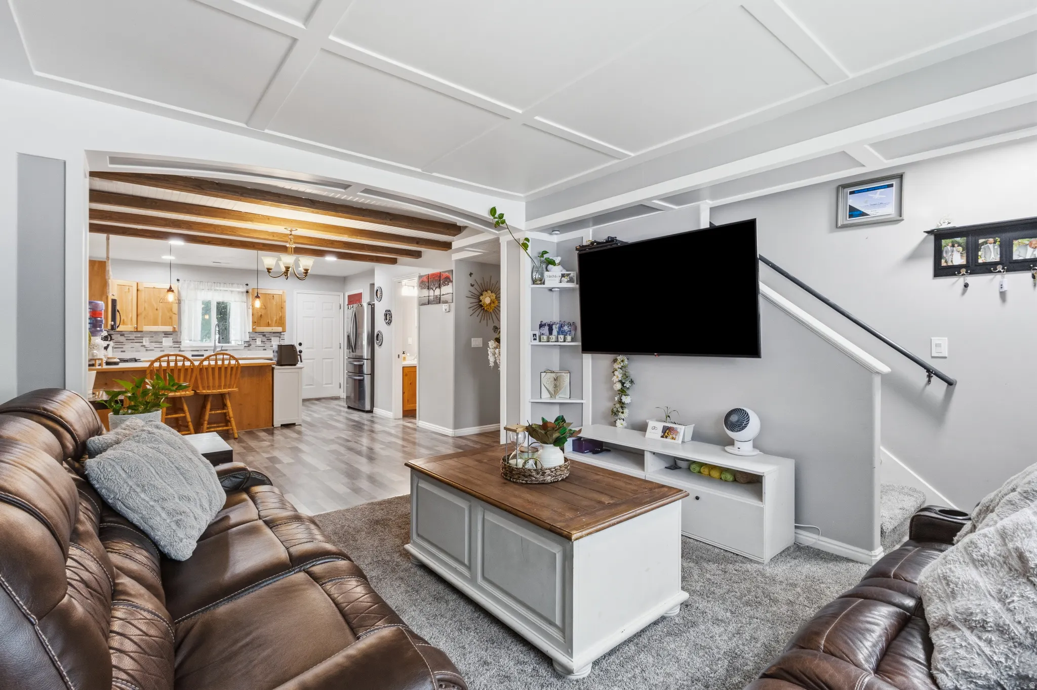 Living room with coffered ceiling and carpet flooring