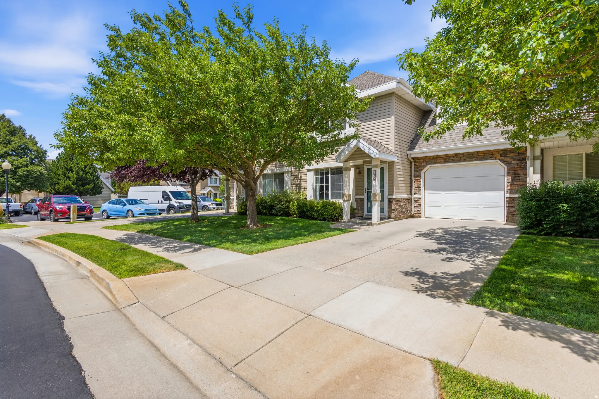Concrete driveway with an attached garage featuring a white door