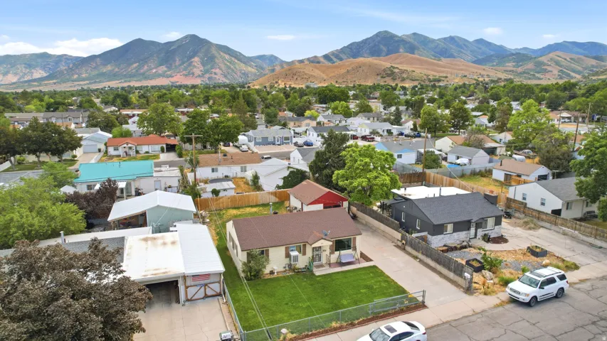 Mountain backdrop frames a residential neighborhood featuring established trees and varied home styles